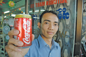 A man in Myanmar showing a Coke can. Coke Myanmar